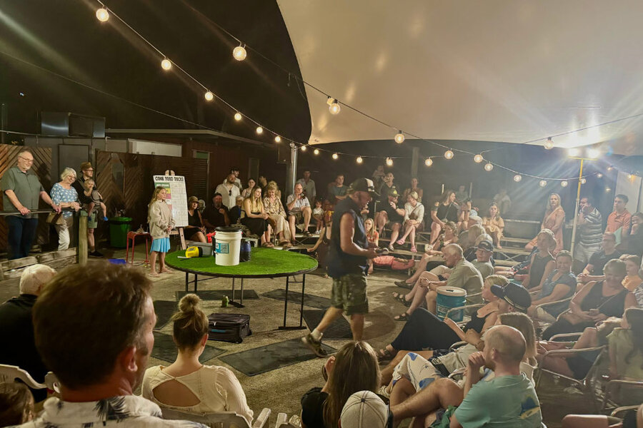 Outdoor performance at Toad Arena under string lights, with a casual crowd gathered around a central performer.